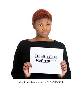 Closeup Portrait Of Young Confused, Sad Worker, Skeptical Woman Holding Sign Health Care Reform, Uncertain Of Universal Insurance Coverage Isolated On White Background. Government Politics Legislation