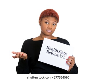 Closeup Portrait Of A Young Confused Skeptical Woman Holding A Sign Health Care Reform, Uncertain Of Universal Insurance Coverage, Isolated On A White Background. Politics, Government , Legislation