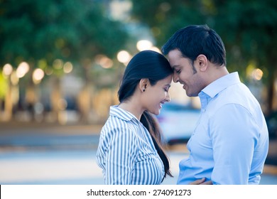 Closeup portrait, young couple in blue shirt, head to head, eyes closed in love smitten, isolated outdoors outside background. Happy moments, positive emotions