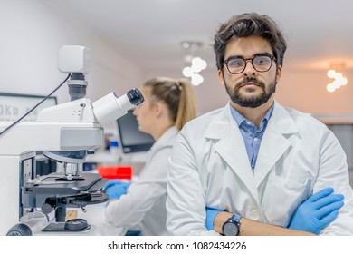 Closeup Portrait, Young Friendly Scientist Standing By Microscope. Isolated Lab Background. Research And Development Sector. Portrait Of Smiling Male Researcher 