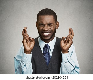 Closeup portrait young funny guy, business man crossing fingers, wishing, hoping for best, miracle isolated black, grey background. Positive human emotions, facial expressions, feelings, attitude - Powered by Shutterstock