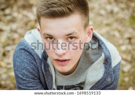 Similar – Stylish teenager sitting on a wooden bench on a city park