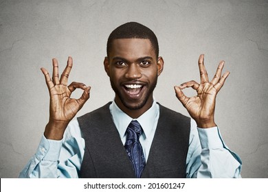 Closeup portrait young handsome, happy, smiling, excited man, corporate employee, worker giving OK sign with fingers, isolated black grey background. Positive human emotion facial expressions, symbol