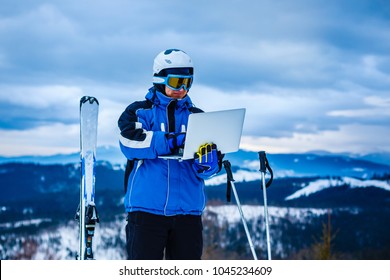 Closeup portrait of young handsome man in sportswear working on his laptop outdoor