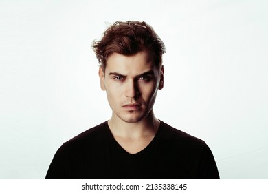 Close-up Portrait Of A Young Handsome Man In The Studio On A Light Background