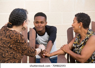 Closeup portrait, young handsome man having conversation with family sitting down, isolated outdoors background