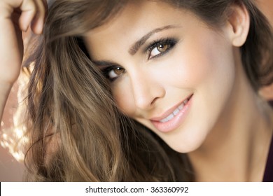 A closeup portrait of a young happy woman with beautiful eyes. Fashion and beauty concept in studio. 