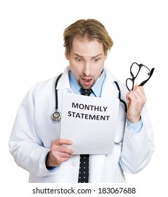 Closeup Portrait Of Young Healthcare Professional Pulling Off Black Glasses, Shocked By The Rising Cost Of Monthly Statement, Isolated On White Background.  Health Care Reform Debate Concept.