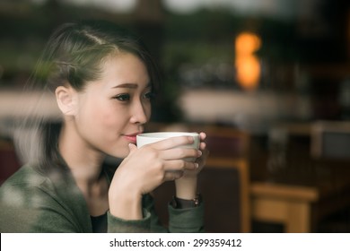 Close-up portrait of young lady enjoying a cup of hot tea - Powered by Shutterstock