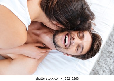 Close-up Portrait Of A Young Laughing Couple In Bed At Home