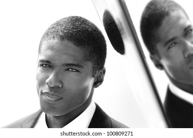 Closeup portrait of young man in black and white against reflective wall