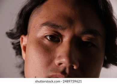 Close-up portrait, young man, intense gaze, serious expression, artistic photography, contemporary portraiture,modern photography, facial features, headshot, dark hair, male model - Powered by Shutterstock