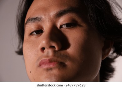 Close-up portrait, young man, intense gaze, serious expression, artistic photography, contemporary portraiture,modern photography, facial features, headshot, dark hair, male model - Powered by Shutterstock