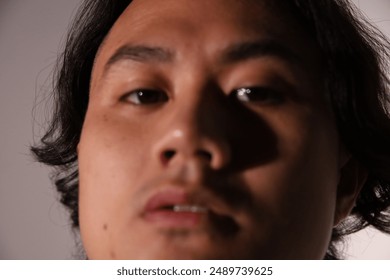 Close-up portrait, young man, intense gaze, serious expression, artistic photography, contemporary portraiture,modern photography, facial features, headshot, dark hair, male model - Powered by Shutterstock