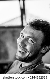 Close-up Portrait Of A Young Man. The Man Laughs. A Sly Smile.