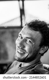 Close-up Portrait Of A Young Man. The Man Laughs. A Sly Smile.