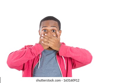 Closeup portrait of a  young man in red hoody looking shocked and surprised in full disbelief hands on mouth eyes open, isolated on a white background. Negative human emotions and facial expressions