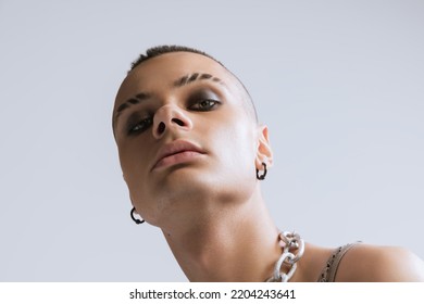 Close-up Portrait Of Young Man With Smoky Eyes Makeup Posing Isolated Over Grey Studio Background. Brutal Look. Concept Of Fashion, Freedom Of Choice, Lifestyle, Lgbt, Generation Z, Trends, Emotions