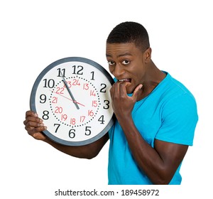 Closeup Portrait, Young Man, Student, Leader Holding A Clock Very Stressed, Pressured By Lack Of Time Running Out, Late For The Meeting, Isolated On White Background. Negative Facial Expression