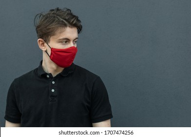 Close-up portrait of young man walking in black t-shirt and red medical mask on dark gray background for protect and stop viruses and coronavirus pandemic, covid-19 outbreak. Guy in red mask - Powered by Shutterstock