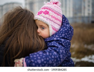 Closeup Portrait Of Young Mother Hugging And Caressing Her Little Child Outdoor In Winter