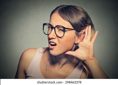 Closeup Portrait Young Nosy Woman Hand To Ear Gesture Trying Carefully Intently Secretly Listen In On Juicy Gossip Conversation News  Isolated Gray Background. Human Face Expression. Hard To Hear 