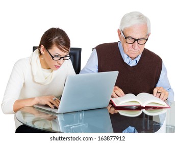 Closeup Portrait Of Young Pretty Woman Working On Laptop And Older Senior Mature Grandpa Man Reading From Book On Table, Isolated On White Background. Generation Differences And Gap Technology Concept