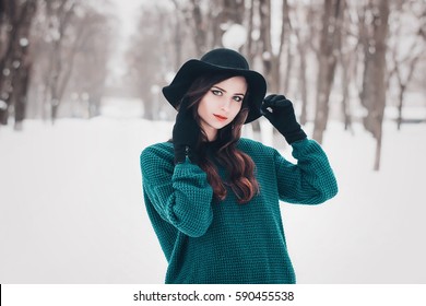 Closeup Portrait Of A Young Pretty Woman In Emerald Oversize Sweater, Gloves And Black Hat