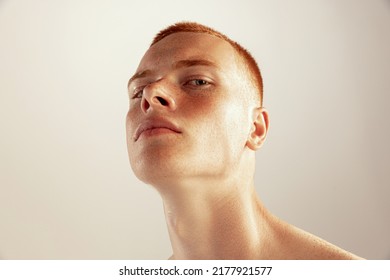 Close-up portrait of young red-haired freckled man posing isolated over grey studio background. Concept of men's health, lifestyle, beauty, body and skin care. Model looking at camera - Powered by Shutterstock