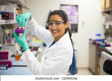 Closeup portrait, young scientist in labcoat wearing nitrile gloves, doing experiments in lab, academic sector. - Powered by Shutterstock