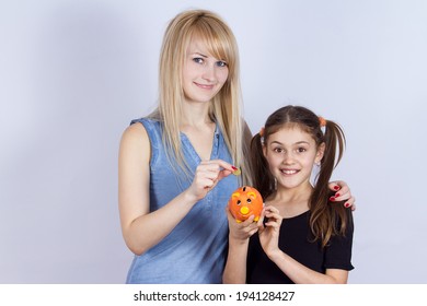 Closeup Portrait Young Smiling Girl Holding Piggy Bank, Happy Mother, Older Sister Deposits Money, Isolated Grey Background. Smart Financial Investment Wealth Decisions. Budget Management, Savings