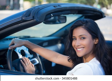 Closeup Portrait Young Smiling, Happy, Attractive Woman Smiling From Behind In Her Brand New Sports Car Drop Top, Hand On Steering Wheel, Isolated Outdoors Background 