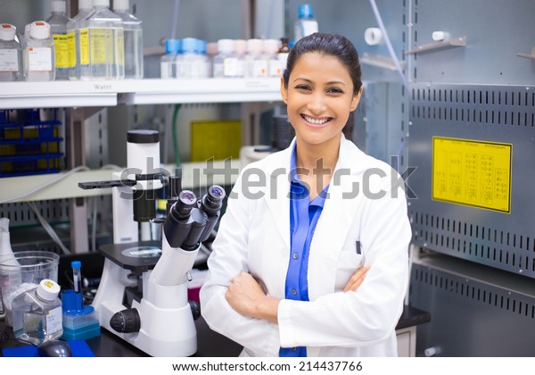 Closeup portrait, young smiling scientist in
white lab coat standing by microscope. Isolated lab background.
Research and
development.