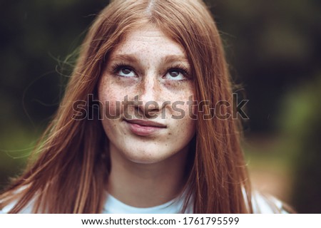 Close-up portrait of young teen freckled ginger girl making goofy face