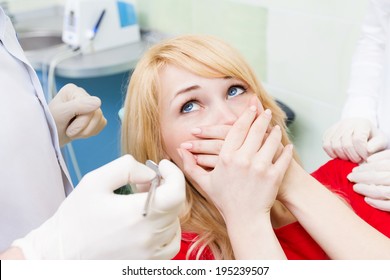 Closeup portrait young terrified girl woman scared at dentist visit, siting in chair, covering her mouth, doesn't want dental procedure, drilling, tooth extraction, isolated clinic office background   - Powered by Shutterstock