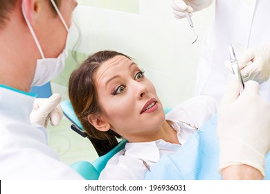 Closeup Portrait Young Terrified Girl Woman Scared At Dentist Visit, Siting In Chair, Funny Looking With Fear, Doesn't Want Dental Procedure Drilling Tooth Extraction Isolated Clinic Office Background