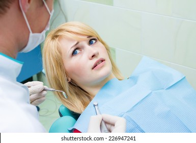 Closeup Portrait Young Terrified Girl Woman Scared At Dentist Visit, Siting In Chair Looking At Doctor Doesn't Want Dental Procedure, Drilling, Tooth Extraction, Isolated Clinic Office Background