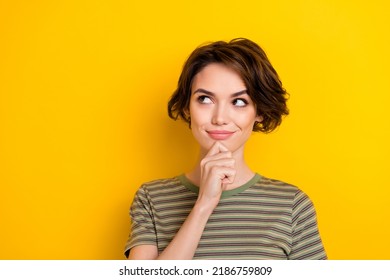 Closeup portrait of young thoughtful intelligent girl hold finger chin looking empty space isolated on bright yellow color background - Shutterstock ID 2186759809