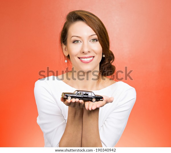 Closeup portrait, young woman, dealership,\
customer service agent holding model black car, offering credit\
line, lease deal, new inventory isolated red background. Automobile\
purchase, financing.
