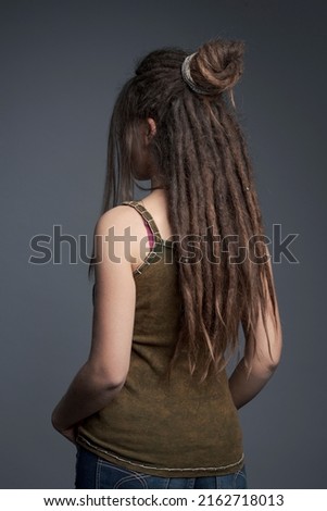 Closeup portrait of young woman,  dreadlocks and long hair￼ back view