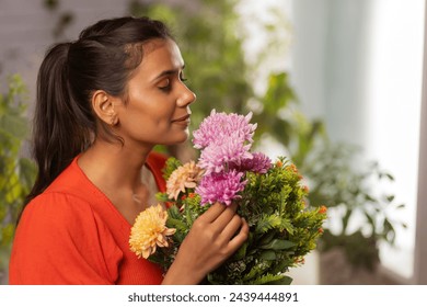 Close-up portrait of a young woman with eyes closed holding flower bouquet and smelling - Powered by Shutterstock