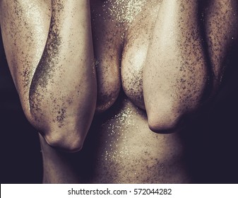 Closeup portrait of young woman with gold glitters on body. Concept fifty shades of black