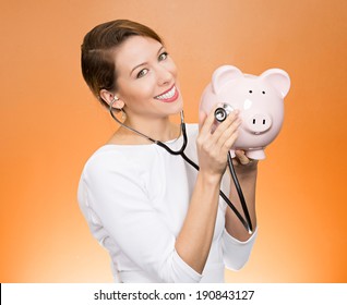 Closeup Portrait Young Woman Listening To Piggy Bank With Stethoscope. Medical Insurance, Medicare Reimbursement. Curious Nurse, Doctor, Patient Or Business Lady. Health Law Coverage, Company Report