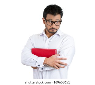 Closeup portrait of young worried guy, nervous student in black glasses, carrying book, looking sideways avoiding eye contact, isolated on white background. Human emotions, face expressions, feelings