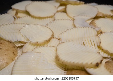 Close-up Of Potatoes Sliced Into Ridged Slices Using A Mandolin In Home Kitchen.