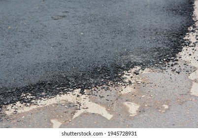 A Close-up Of A Pothole Repair On The Road, Repaired Patched Asphalt Driveway. Old And New Asphalt On The Pavement. 