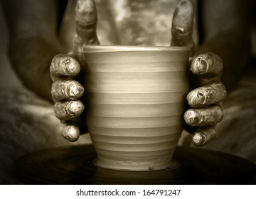 Close-up of potter's hands with the product on a potter's wheel - Powered by Shutterstock