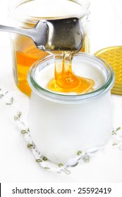 closeup from pouring honey into a glass with yoghurt