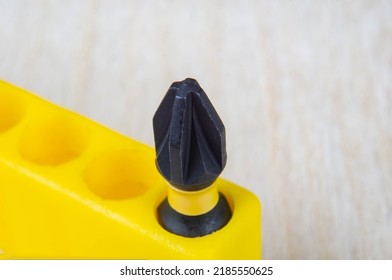 Close-up of a Pozidriv type screwdriver bit in a yellow bit holder