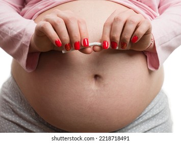 Close-up Of Pregnant Woman Breaking Cigarette Isolated On White Background As Bad Habit Concept